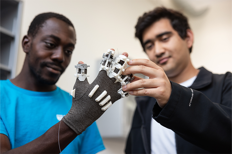 student wearing smart glove next to other student